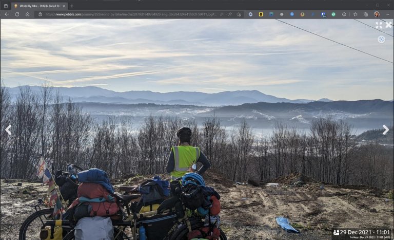 Screenshot of photo on Pebbls website of cyclist looking at mountain view.